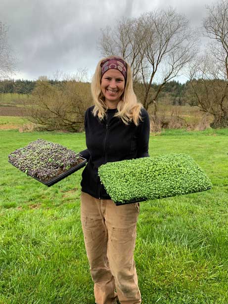 Laura holding microgreen trays